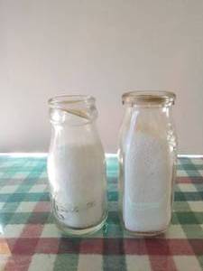 lot 81 image: Lot of 2 -12 pint glass milk bottles Mistleai and Meadon with lids