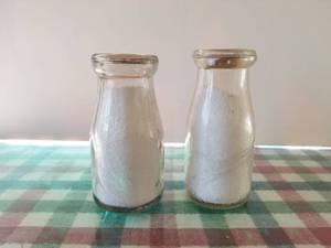 lot 82 image: Lot of 2 -12 pint glass milk bottles, 1 is Dairyland both with lids