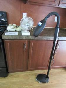 lot 77 image: Black gooseneck light, fan, and Uniden home phone