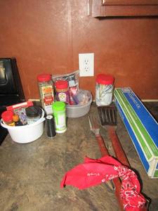 lot 98 image: BBQ lot- opened meat seasoning, plastic wrap and large utensils
