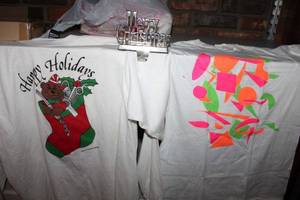 lot 1053 image: T-Shirts Lot Happy Holidays Long-Sleeve and Markham Hair Care T-Shirts PLUS Stocking Hanger