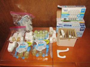 lot 44 image: Lot- New and used glade plug ins linen scent refills and plugins, Box of ceramic wall hooks 3 boxes of 60 watt light bulbs