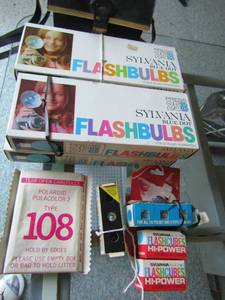 lot 105 image: Vintage Sylvania flashbulbs x 4 boxes, polaroid type 108 film, camera case, 2 cubes and8 flashes