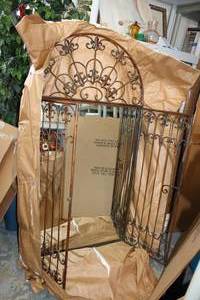 lot 5 image: Wall Mirror with Fleur De Lis Design and Metal Gate Front, 55.5 x 30.5