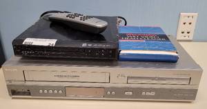 lot 24 image: (1) PHILIPS VCRDVD PLAYER MODEL DVP3150V37 WITH REMOTE, (1) DYNEX DVD PLAYER MODEL DX-DVD2, AND MORE AS SHOWN.
