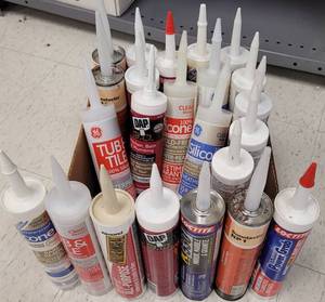 lot 143 image: (23) CAULKINGS, ADHESIVES INCLUDING DAP AND LOCKTITE AND MORE AS SHOWN. SOLD 23 X THE MONEY