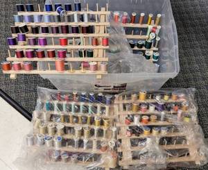 lot 338 image: LARGE LOT OF ASSORTED SPOOLS OF SEWING THREAD WITH 4 WOODEN WALL MOUNTING RACKS AS SHOWN. TAKE A LOOK