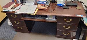 lot 576 image: WOODEN OFFICE DESK IN STYLE SHOWN. CONTENTS NOT INCLUDED APPROX. 66 W x 29 H x 20 D.