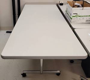 lot 782 image: HEAVY DUTY WHEELED OFFICE TABLE WITH FOLDING LEGS AS SHOWN. APPROX. 95.5 L x 29.75 W x 30.5 H.