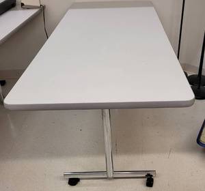 lot 783 image: HEAVY DUTY WHEELED OFFICE TABLE WITH FOLDING LEGS AS SHOWN. APPROX. 71.5 L x 29.75 W x 30.5 H.
