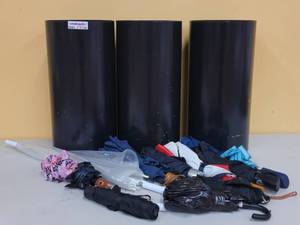 lot 786 image: (3) STEEL UMBRELLA HOLDERS WITH VARIOUS UMBRELLAS AS SHOWN. EACH APPROX. 10 Dia. x 20 H. SOLD 3 X THE MONEY