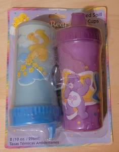 lot 21 image: 2004 CARE BEARS INSULATED SPILL PROOF BABY CUPS IN PACKAGING AS SHOWN.