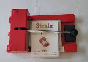 lot 132 image: SIZZIX ORIGINAL RED DIE CUTTING MACHINE WITH REPLACEMENT CUTTING PAD AS SHOWN.