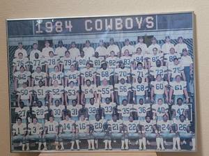 lot 7 image: VINTAGE LARGE SIZE FRAMED 1984 DALLAS COWBOYS TEAM PICTURE POSTER AS SHOWN. APPROX. 30 W x 22 H.