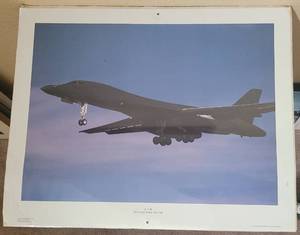 lot 31 image: VINTAGE 1990 B-1B BOMBER ROCKWELL INTERNATIONAL POSTER AS SHOWN. THIS ITEM STILL HAS THE ORIGINAL PLASTIC WRAP. APPROX. 20 W x 16 H.