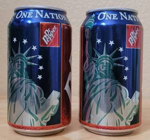 lot 56 image: (2) DR. PEPPER ONE NATION... INDIVISIBLE STATUE OF LIBERTY COMMEMORATIVE UNOPENED 12 OZ CANS AS SHOWN. (SOLD 2 X THE MONEY)