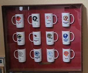lot 60 image: CUSTOM FRAMED VINTAGE 1980 SONIC DR. PEPPER PROMOTIONAL NFL MUGS INCLUDING DALLAS COWBOYS, HOUSTON OILERS, AND MORE AS SHOWN. SEARCH THESE UP GREAT COLLECTIBLE APPROX. 31.25 W x 27.5 H x 3 D.