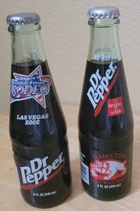 lot 68 image: (1) 1998 HAMILTON LADY BULLDOGS UIL 2A BASKETBALL STATE CHAMPS AND (1) 2002 LAS VEGAS PRCA WRANGLER NATIONAL FINALS RODEO COMMEMORATIVE DR. PEPPER BOTTLES AS SHOWN. (SOLD 2 X THE MONEY)