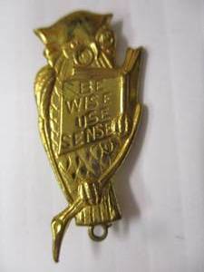lot 59 image: Vintage Be Wise Use Sense Owl Pinback Pin. It is approx. 1 58, it is missing a charm that would hang from the bottom