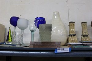 lot 135 image: Glassware on Shelf Blue and White Blown Glass Stemware (Tallest is 9), 2 Tiles, Ceramic Candle Holders and More
