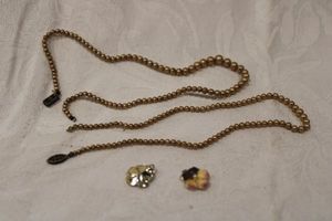 lot 192 image: (2) glass pearl necklaces (one with sterling clasp, one has missing clasp). Marked sterling and (2) enamel and pearl earrings or charms in pansy form.