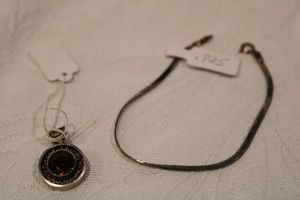 lot 198 image: Sterling silver herringbone 7L bracelet Marked Made In Italy 925 and a sterling and faceted glass pendant. Hallmark on clasp