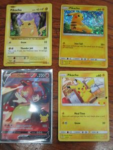 lot 64 image: (4) POKEMON CARDS - (1) CHARIZARD, (3) PICACHU ONE IS FROM THE LAST XY SERIES IN 2016