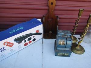 lot 26 image: Belmint handheld massager NIB, Uncle sams 3 coin register bank,  wooden candlestick wall mount and 2 brass candlesticks