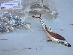 lot 55 image: bag of Dolphin Bottle openers, Bag of hot and cold shower curtain hooks