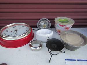 lot 84 image: Sterling and Noble Red wall clock, soap dish, 2 citronella outdoor candles small table top fan