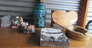 lot 120 image: Covered green glass jar full of matchbooks    Bear sitting on books and 1 Bundle of Books Dcor and Mexican ashtray