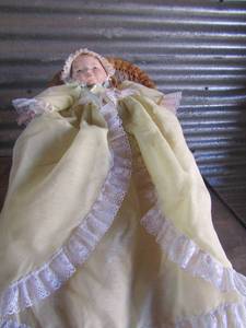 lot 200 image: Grace putman 1922 porcelain doll sitting in wicker chair