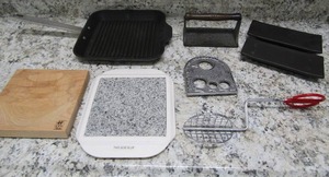 lot 143 image: Kitchen lot- Villa wear cast iron skillet, J A HENCKELS Cutting board  Marble cheese board,   taco shell maker and more