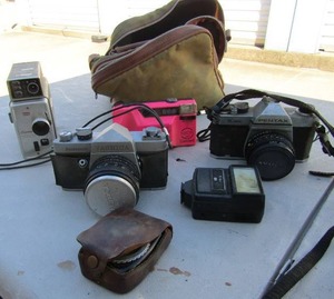 lot 383 image: Exposure meter,  Kodak projector,  camera bag,  pink neon concord camera,  Vivitar 125, Pentax K-1000 camera,  Yashica camera