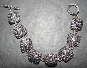 lot 49 image: LOVELY CHARM BRACELET WITH STAMP AS SHOWN - UNKNOWN METAL CONTENT
