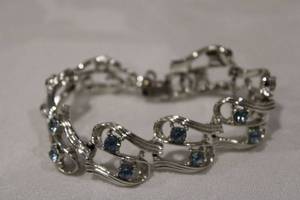 lot 386 image: Coro brand silver tone and blue crystal articulated bracelet. 7L Missing one blue crystal. Marked Coro