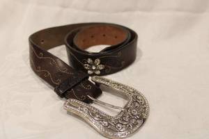 lot 444 image: Justin branded leather belt with detachable rhinestone buckle and flower form conchos. Size 38 Model Marked with Justin logo