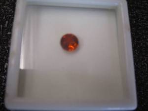 lot 20 image: 1.15 Ct Avg 6mm Rd. Red Spessartite Garnet In Display Case