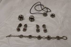 lot 445 image: Fashion gun metal finish matching jewelry in Fleur De Lis form. Includes 7L bracelet, (2) sets of earrings and (2) adjustable rings, pendant plus