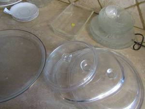 lot 112 image: Glass pan lids, 12 serving platter, rose design clear glass plates and bowls, and caring bake pan