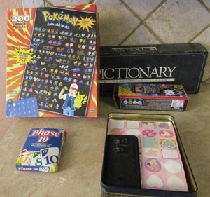 lot 165 image: Pokmon puzzle 250 pieces, Pictionary, phase 10, and tin full of stickers