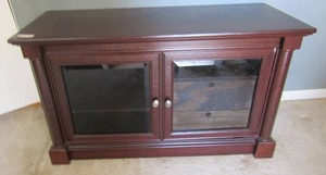 lot 14 image: TV entertainment center 28x49x19 Two front doors secret drawers 3 tier shelving right bottom side needs some repair