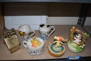 lot 130 image: Snoopy Lot Metal Piggy Bank, Mugs, Ceramic Swinging Snoopy Music Box, and Skating Snoopy Music Box
