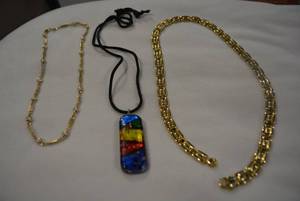 lot 334 image: Necklace selection. Includes a 20 gold necklace with lobster clasp, a fancy elongated and pearl 16 and a Dichroic glass pendant necklace on cord. No markings.