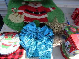 lot 29 image: Oval Santa rug, 4 holiday tins,  Blue bow door dcor and gold star tree topper