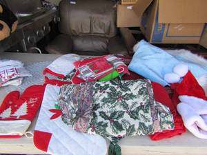 lot 48 image: Tub full of table cloths for all seasons dish towels holiday hats