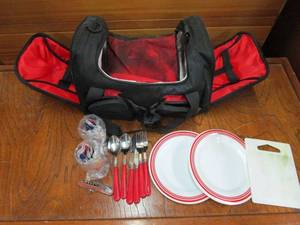 lot 84 image: PICNIC BAG CONTAINING PLATES, UTENSILS, CUPS, MULTI TOOL WINE OPENER, CUTTING BOARD. BAG HAS ELASTIC STRAPS TO KEEP EVERYTHING IN PLACE &amp A SPOT FOR A WINE BOTTLE, BAG ITSELF HAS DAMAGE, SEE PICS