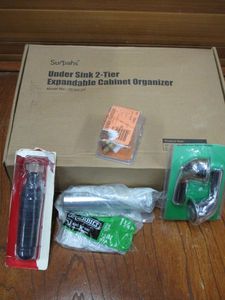 lot 111 image: NEW UNDER SINK W-TIER EXPANDABLE CABINET ORGANIZER, 1-14 BRASS SLIP JOINT 24 GAUGE 12, DRAIN BLADDER FOR CLEARING SMALL HOUSEHOLD DRAINS, FAUCET HANDLES