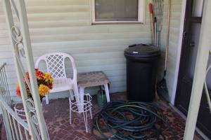 lot 186 image: Yard Tools, Hoses, Patio Chair and Table, Wire Plant Stands, and Trash Can