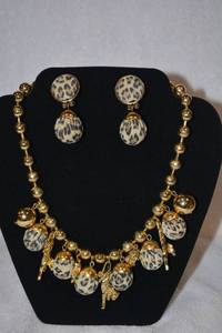 lot 204 image: Leopard theme 16L necklace and matching clip earring demi parure set. Necklace has gold finish beads, leopard cloth covered beads and figural 3 dimensional leopard and elephant pendants.